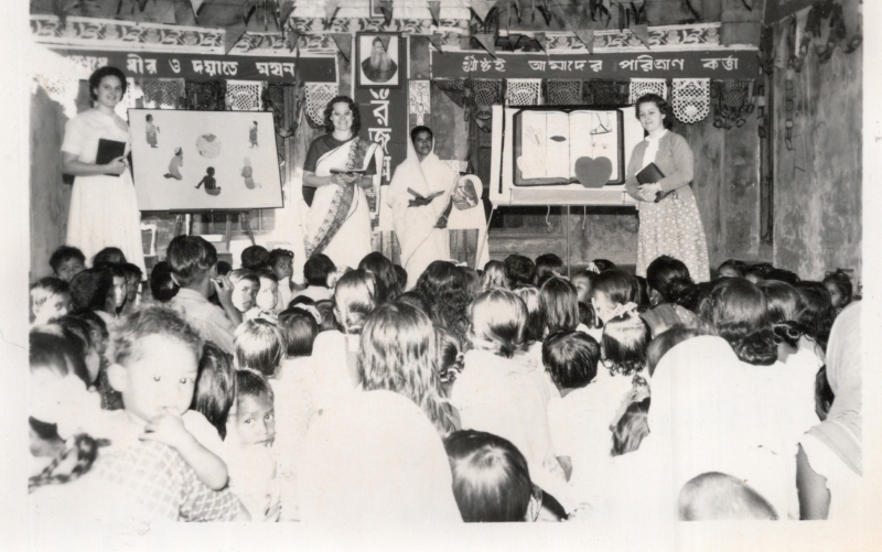 Image from the Olsons, missionaries to Pakistan, captioned, "Kids Krusade, Jan. 1963, Left to Right: Ruth Tarno, Marian Olson, Mrs. Biswas, Montiel Peck, 150 cute kids, Gopalganj"