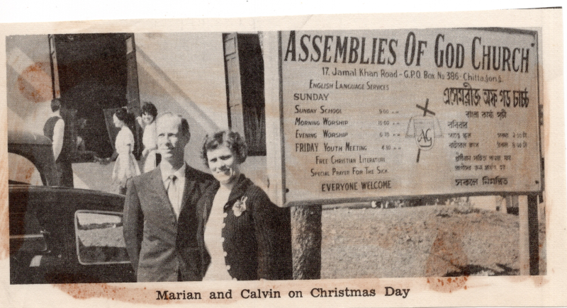 Portrait of the Olsons next to an Assemblies of God church sign with the caption, "Marian and Calvin on Christmas Day"