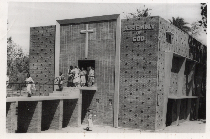 Image of a church exterior with a cross and name, "Assembly of God." A caption reads, "Dedicated Easter Sunday 1960"