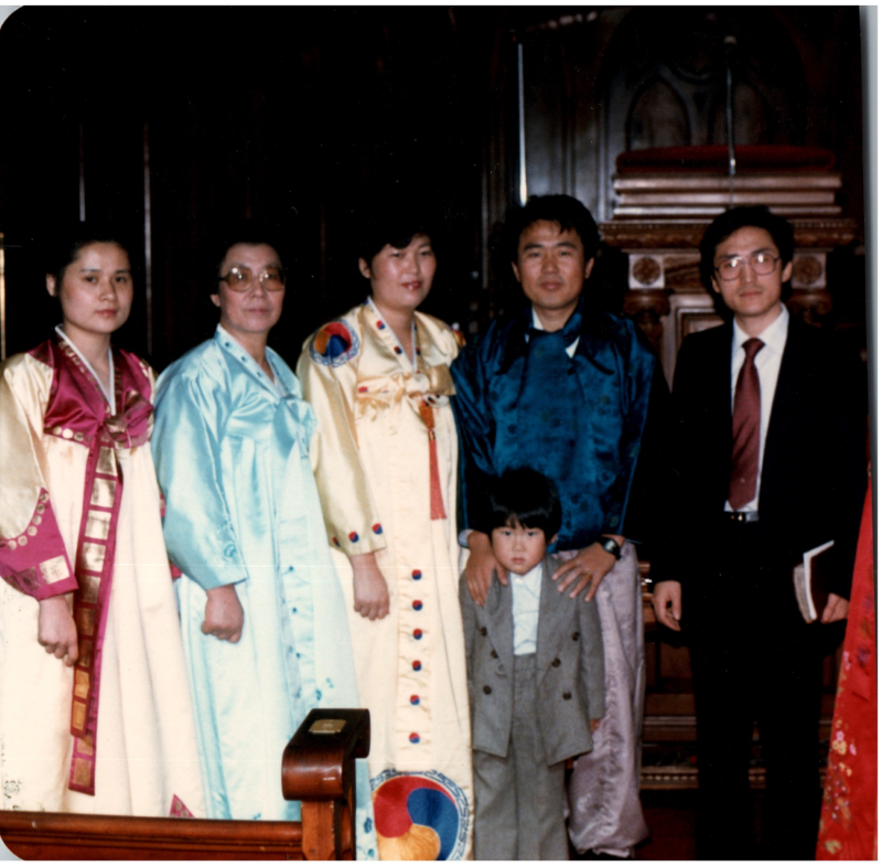 A group with several people dressed in traditional Korean clothing smile together in the sanctuary