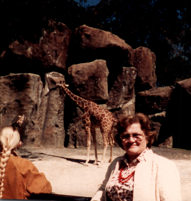Mrs. Bogdan smiles with a giraffe