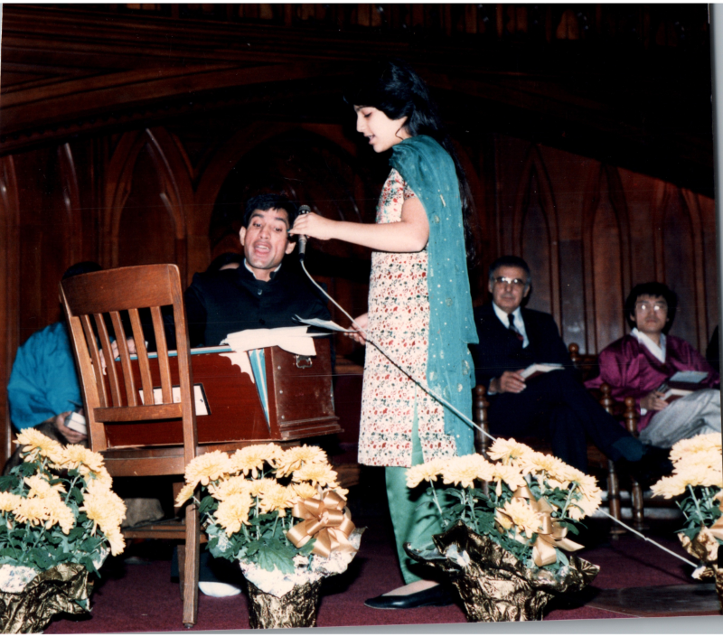 A man and woman sing together into a microphone