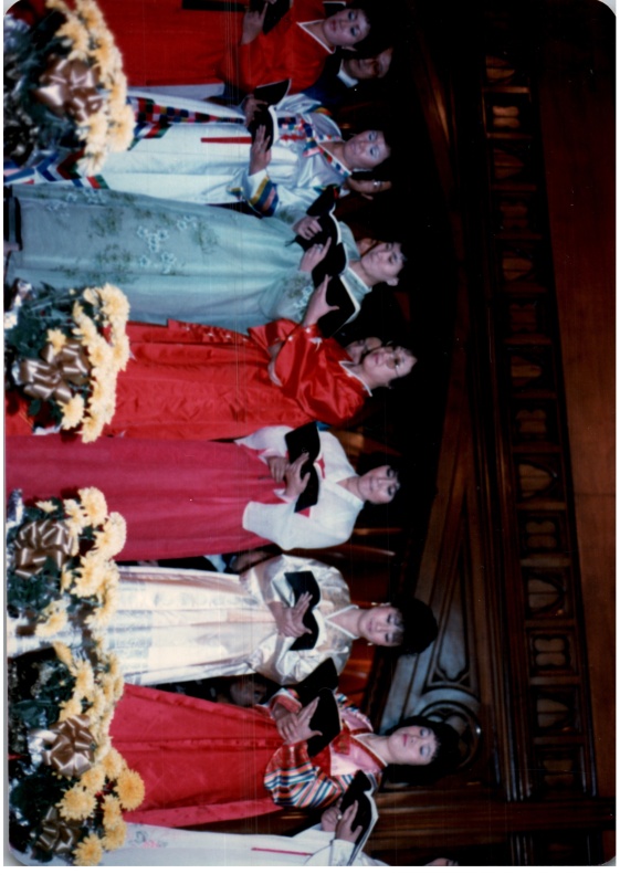 Women in hanboks lead a song from a hymnal
