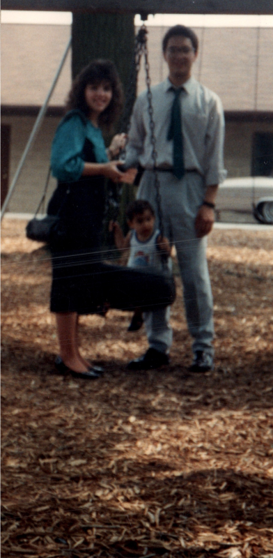 The DaSilvas with their child in a tire swing