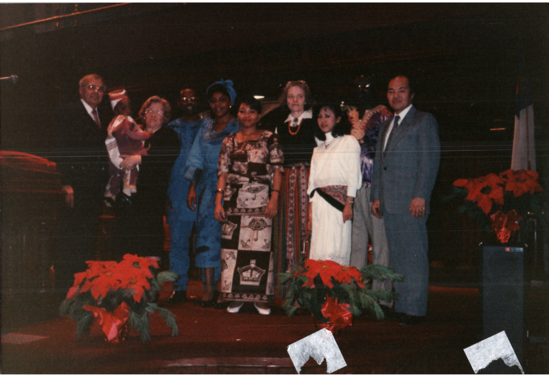 A group in international clothing poses for a picture with the Bogdans in the sanctuary