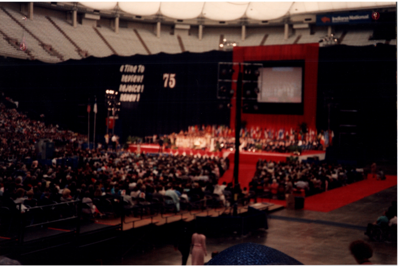 Image of the stage at General council with the slogan, "A Time to Review! Rejoice! Renew!" and a "75"
