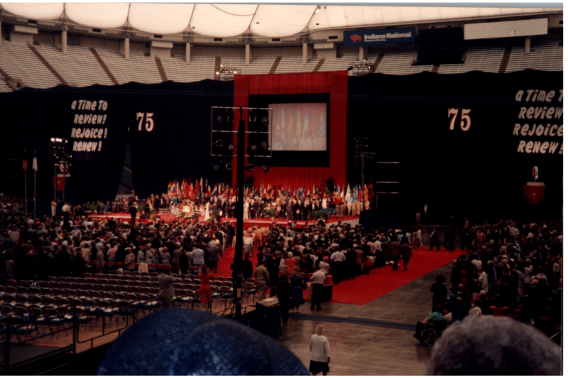 Image of the stage at General council with the slogan, "A Time to Review! Rejoice! Renew!" and a "75"