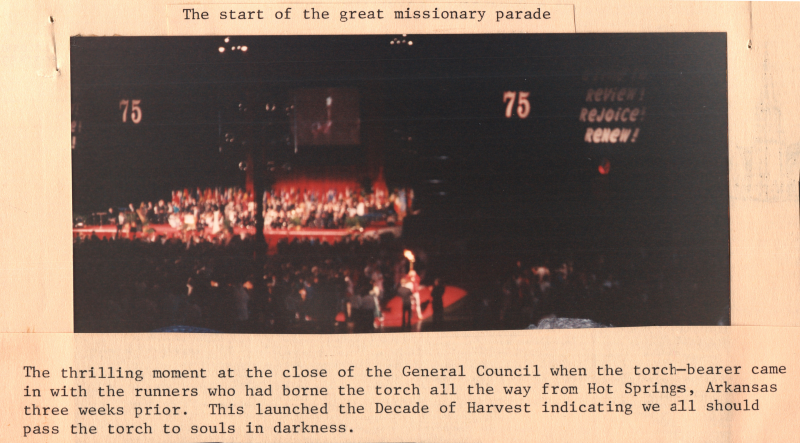 Caption: "The start of the great missionary parade. The thrilling moment at the close of the General Council when the torch-bearer came in with the runners who had borne the torch all the way from Hot Springs, Arkansas three weeks prior. This launched the Decade of Harvest indicating we all should pass torch to souls in darkness."