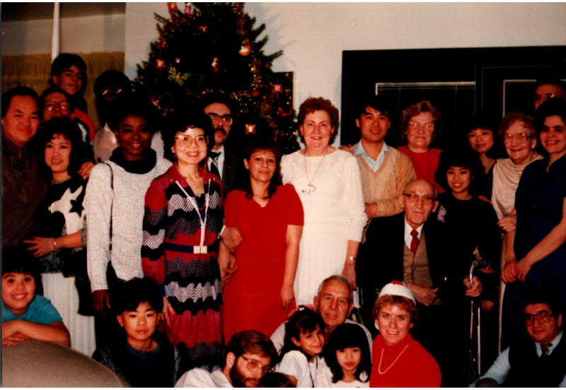 Congregants smile for a photograph in front of a Christmas tree
