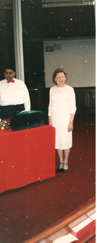 A woman stands next to the bell choir