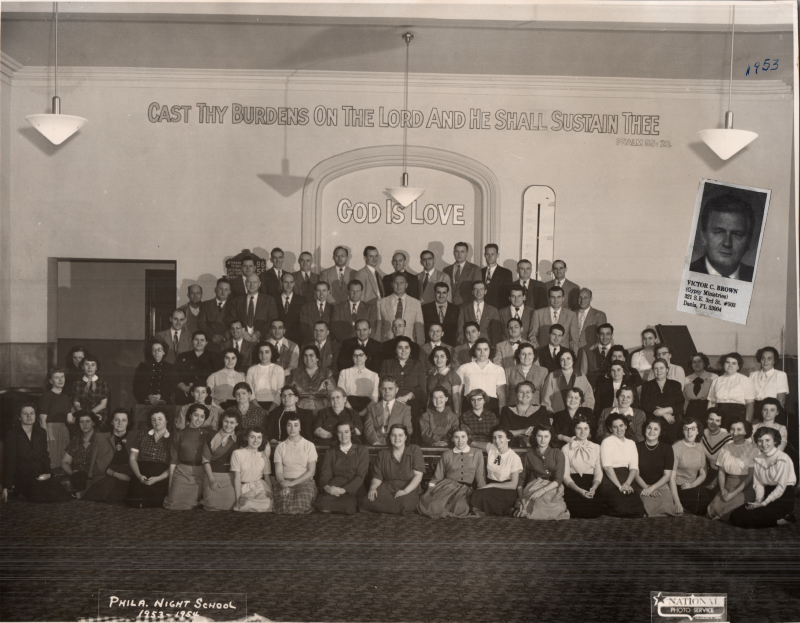 Portrait of the Philadelphia Night School class of 1953-1954. There is a clipping of Victor C. Brown of "Gypsy Ministries" pasted onto the picture
