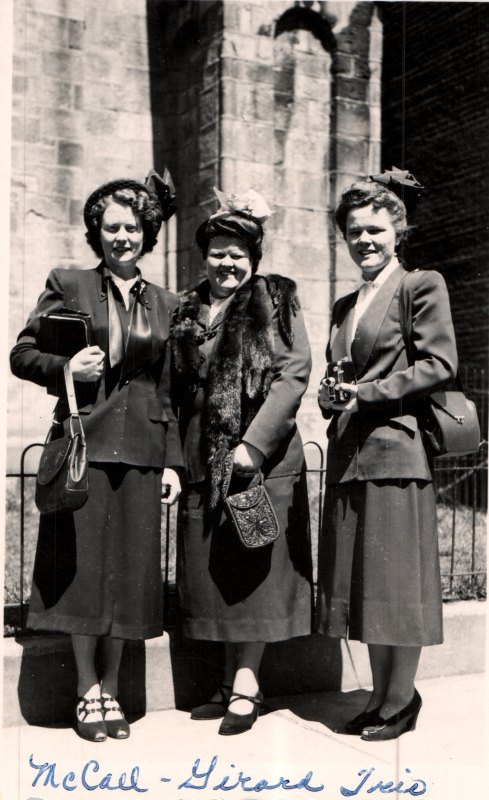 Three women smile for a portrait outside of the building at 19th and Green Streets with the caption, "McCall Girard Trio."