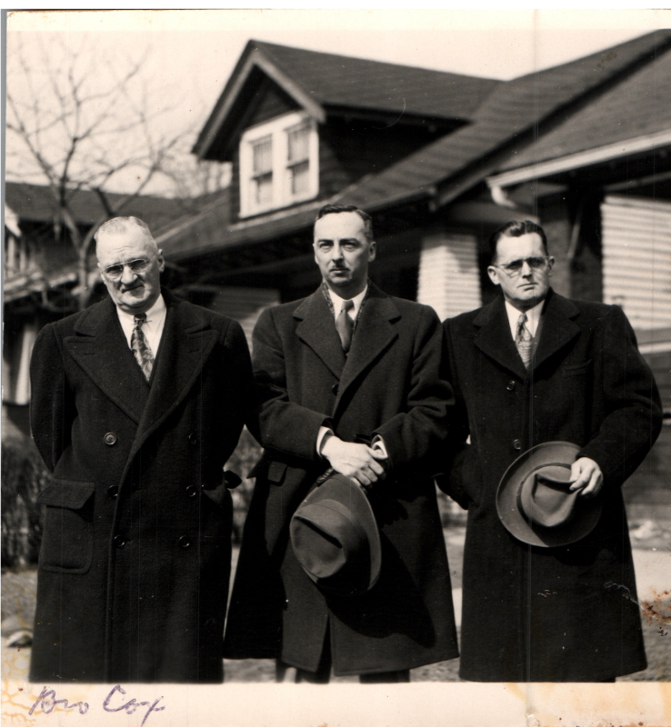Portrait of three men, the one on the far left is Brother Cox