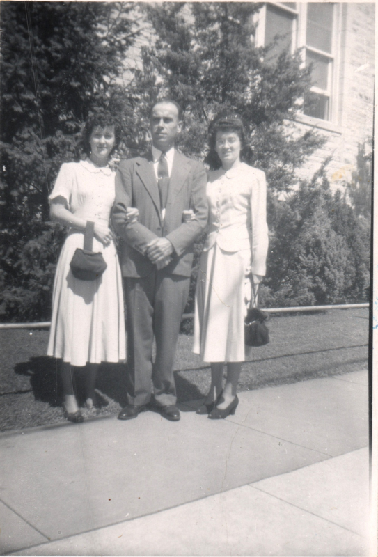 Tow women and a man smile together outside the building at 19th and Green