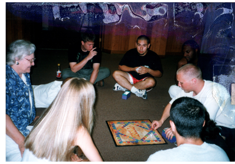 A group, including Mrs. Bogdan, play a board game