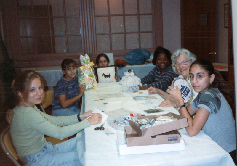 A group of girls sit around a table with Mrs. Bogdan