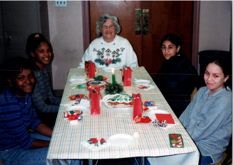 A group of girls sit around a table with Mrs. Bogdan