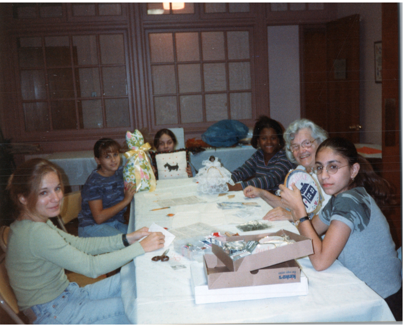 A group of girls sit around a table with Mrs. Bogdan