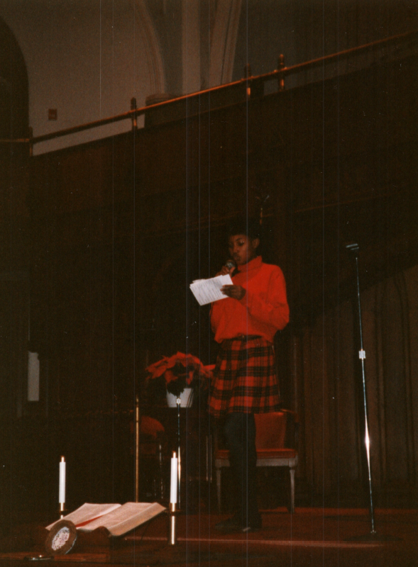 A girl reads from a paper on stage