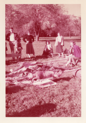 Members of the choir stand around roasting pigs